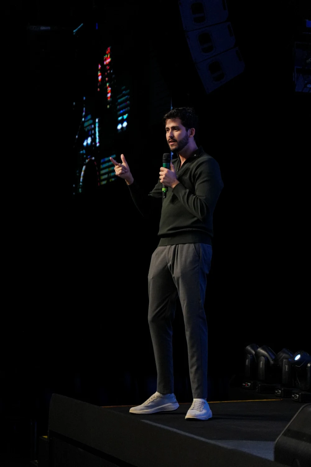 JP falando no palco, com um microfone na mão